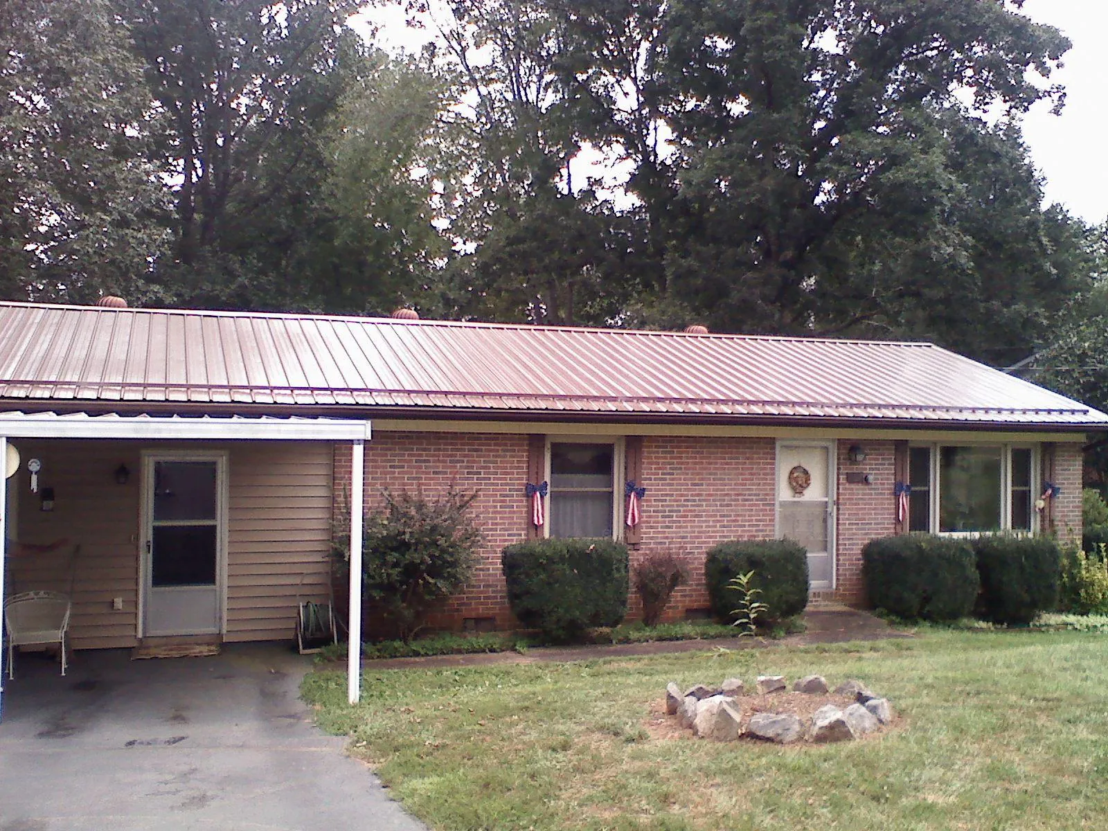 Bronze metal roof and carport on a brick ranch home — Roof Repair work by our crew in Sterling